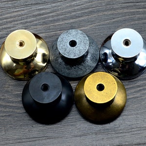 Pode incluir: Cinco bot&otilde;es de arm&aacute;rio diferentes em v&aacute;rios acabamentos, incluindo ouro, prata, preto e cinza. Os bot&otilde;es s&atilde;o redondos com um pequeno furo no centro para montagem.