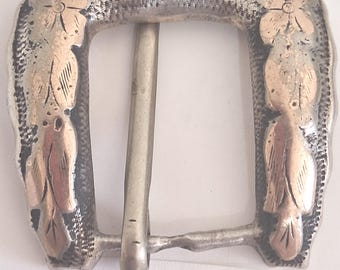 May include: Silver-toned belt buckle with gold-colored floral accents. The buckle has a horseshoe shape with a central bar and a decorative oval at the top. The number "25958" is printed at the bottom.