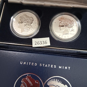 May include: A set of three ceramic mugs with a speckled, matte finish. The mugs are in shades of cream, light gray, and dark gray. Each mug has a simple, minimalist design, perfect for coffee or tea. The mugs are stacked on top of each other.