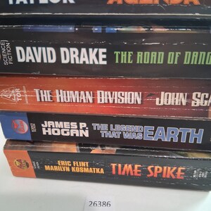 May include: A stack of science fiction books with titles including "Agenda", "The Road of Danger", "The Human Division", "The Legend That Was Earth", and "Time Spike". The books have black, orange, and blue spines with white and orange lettering.