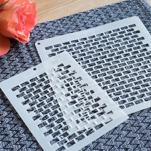 Könnte beinhalten: Zwei weiße Kunststoffschablonen mit einem Ziegelmuster, eine große und eine kleine, werden auf einer strukturierten grauen Oberfläche gezeigt. Die Schablonen sind mit "the MINT art" beschriftet. Eine rosa Rose befindet sich in der oberen linken Ecke.