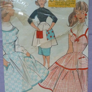 May include: Vintage sewing pattern featuring illustrations of women's aprons and dresses. The pattern includes a variety of designs, with one apron featuring a red and blue polka dot pocket. The text on the pattern reads "3431-A" and "Gr. 42: 3.10 m / 90".