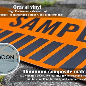 May include: A close-up of a black and orange sign with the word "SAMPLE" printed in black letters. The sign is made of aluminium composite material and is labelled as a premium grade outdoor sign. The sign is waterproof, fade resistant, and UV protected.