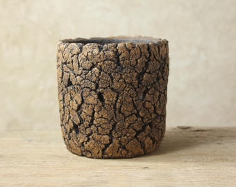 May include: A set of three ceramic mugs with a speckled, matte finish. The mugs are in shades of cream, light gray, and dark gray. Each mug has a simple, minimalist design, perfect for coffee or tea.