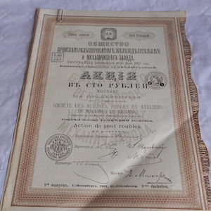 Op de afbeelding: Een vintage aandeelcertificaat voor de Briansk Rail Rolling, Ironworks and Mechanical Plant, gedateerd 1901. Het certificaat is voor 100 roebel en is gedrukt in het Russisch en Frans. Het certificaat is ondertekend door de directeuren van het bedrijf en de kassier.
