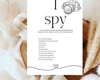 May include: A black and white printable I Spy game for a wedding reception. The game features a camera icon and a list of things to find, such as the bride and groom laughing, the first dance, and the best dressed guest.