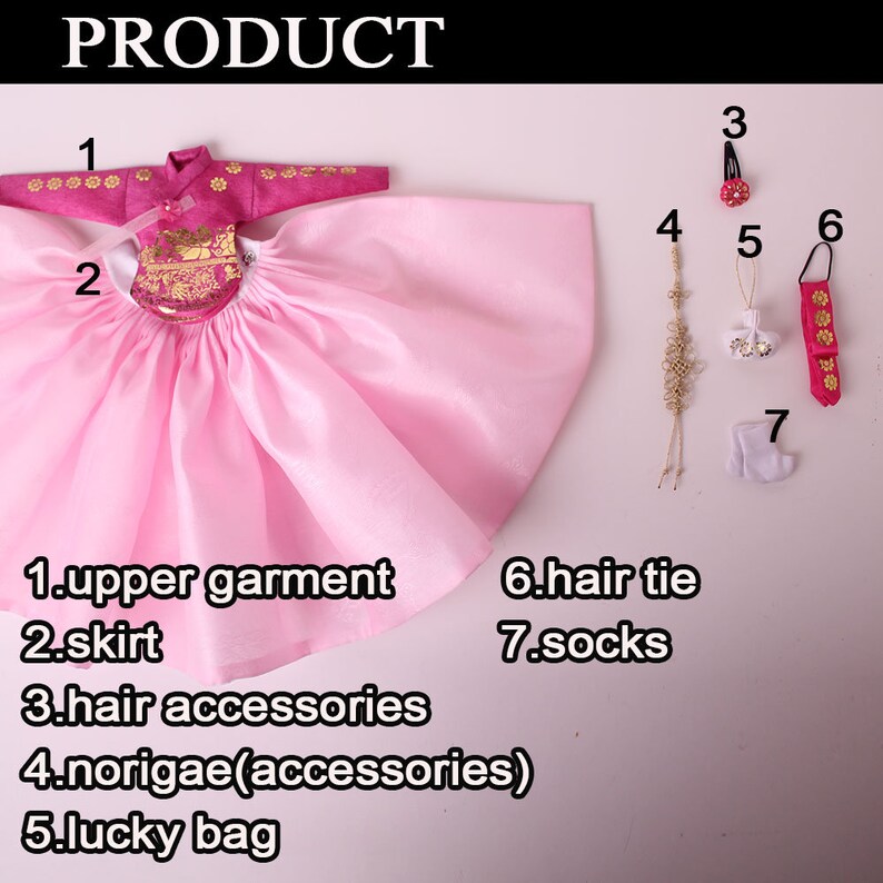 Pode incluir: Um traje tradicional de boneca coreana, com uma parte superior e saia rosa, com detalhes dourados. Os acess&oacute;rios incluem grampos de cabelo, um saco da sorte e meias. O traje &eacute; para uma boneca.