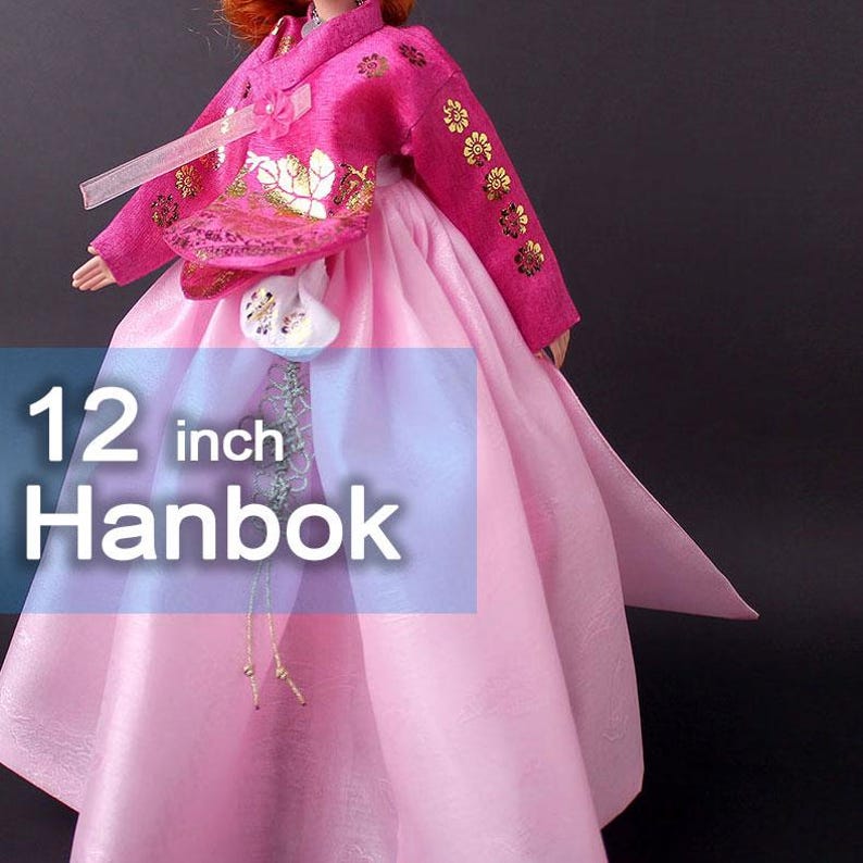 Pode incluir: Boneca Hanbok de 30 cm com uma roupa tradicional coreana. A roupa da boneca &eacute; rosa vibrante com bordados florais dourados nas mangas e no corpete. A saia &eacute; de um tom rosa mais claro.