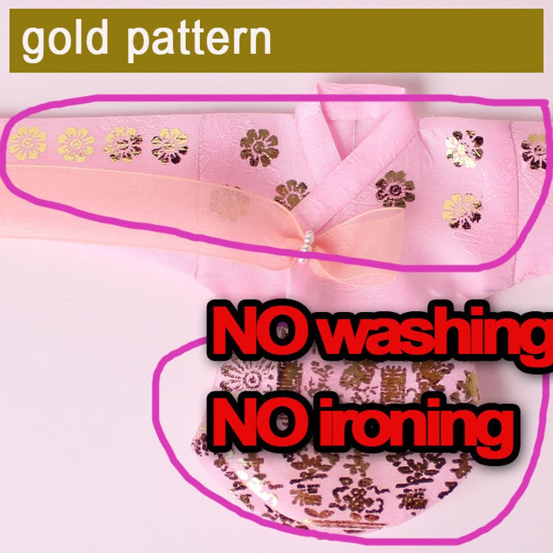 Puede incluir: Prenda rosa con detalles florales dorados. Incluye un lazo con una perla. El texto "NO washing" y "NO ironing" es visible.