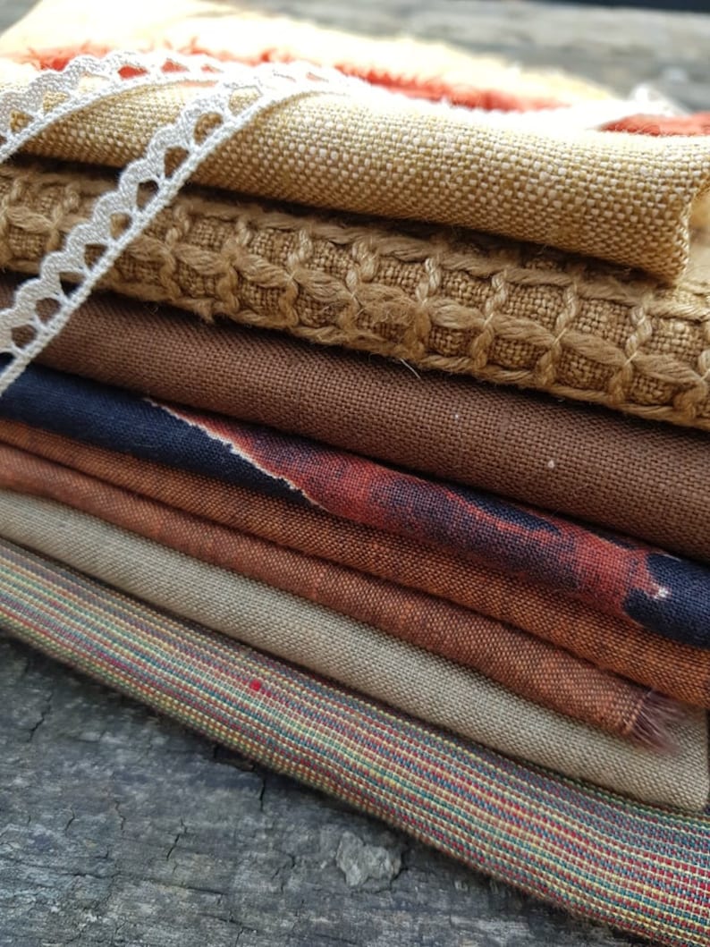 Puede incluir: Un conjunto de ocho muestras de tela en diferentes tonos de marr&oacute;n, beige y &oacute;xido. Las telas tienen diferentes texturas, incluyendo tejido, lino y arpillera.