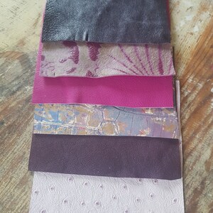 May include: A stack of six different leather swatches in various colors and textures, including black, pink, purple, and white.