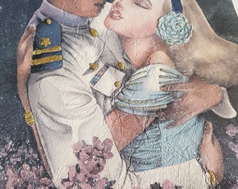 May include: A vintage leather jacket with a painted image of a couple embracing. The man is wearing a white uniform with gold accents and the woman is wearing a blue dress with a white flower in her hair. The background is a dark blue with stars.