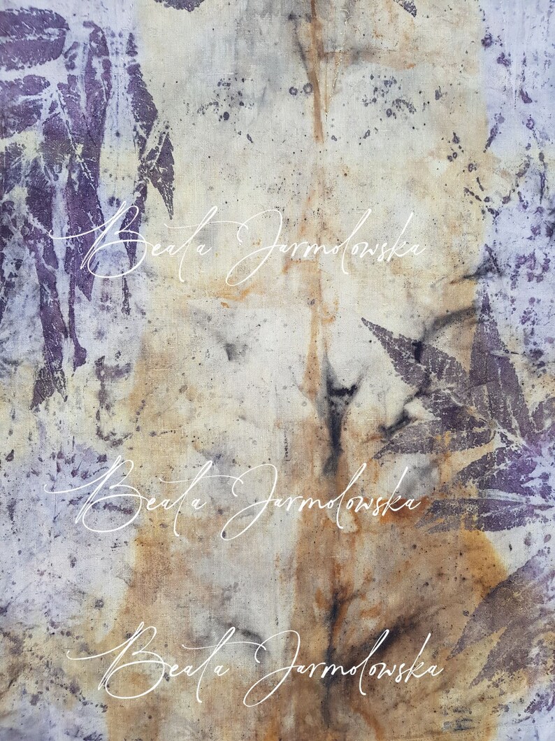 May include: A close-up of a light brown fabric with a purple leaf pattern and the text "Beata Jarmolowska" written three times in white cursive.