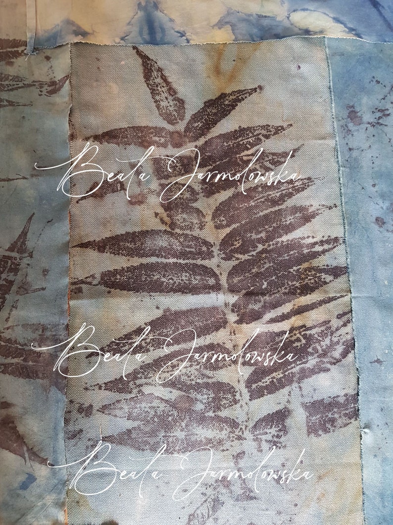 May include: A close-up of a fabric art piece with a brown leaf pattern and the text "Beata Jarmolowska" repeated three times.
