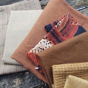 Puede incluir: Un conjunto de seis muestras de tela en varios tonos de marr&oacute;n, beige y negro. Las telas tienen diferentes texturas, incluyendo un patr&oacute;n a rayas, un color s&oacute;lido y un dise&ntilde;o estampado.