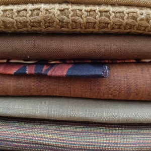 Puede incluir: Un conjunto de seis muestras de tela de diferentes colores, que van del marr&oacute;n al beige y al gris. Las telas tienen diferentes texturas, incluyendo tejidos, tejidos de punto y estampados.