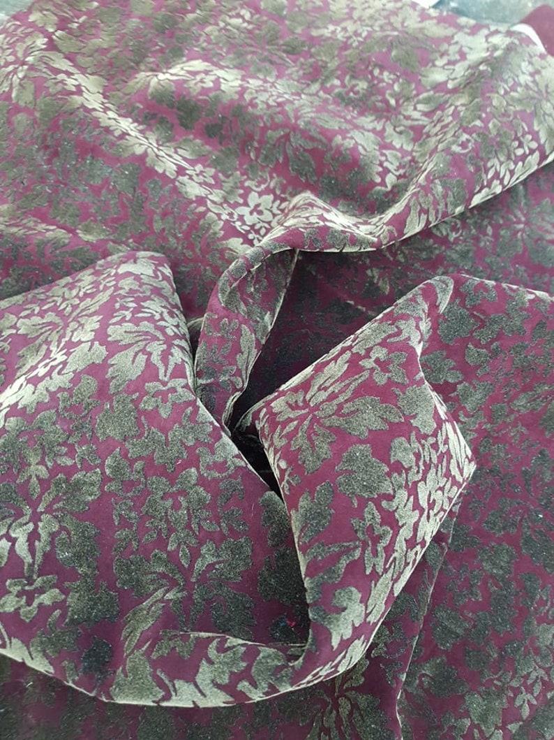 May include: Burgundy velvet fabric with a gold floral pattern.