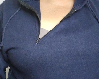 May include: A navy blue hooded sweatshirt with a quarter-zip closure. The zipper is black, and the hood has drawstrings. The sweatshirt is made of a soft, comfortable material.