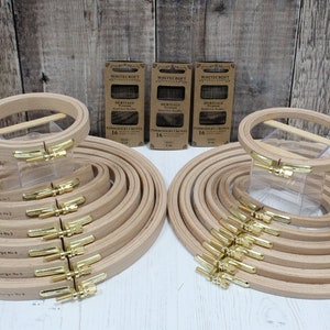 Op de afbeelding: Een set van 16 houten borduurringen in verschillende maten. De ringen zijn in twee groepen gerangschikt, met de grotere ringen onderaan en de kleinere ringen bovenaan. De ringen zijn gemaakt van natuurlijk hout en hebben een messing schroefsluiting. De ringen zijn 8 mm en 16 mm breed.