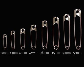 May include: A set of ten safety pins in various sizes, ranging from 19mm to 57mm. The pins are arranged in order of size, with the smallest pin on the left and the largest pin on the right.