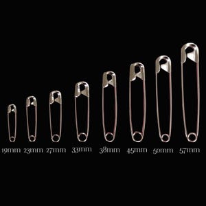 May include: A set of eight silver-toned metal safety pins arranged in increasing size order from left to right. The pins are labelled with their respective lengths of 19mm, 23mm, 27mm, 33mm, 38mm, 45mm, 50mm, and 57mm printed below each item.