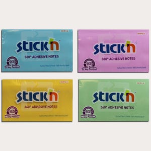 Op de afbeelding: Vier pakken Stick'n 360° zelfklevende notitieblaadjes in blauw, roze, geel en groen. Elk blok is 76x127mm en bevat 100 vellen. De verpakking toont het Stick'n-logo en productinformatie.