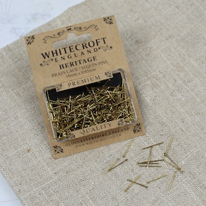 Puede incluir: Un paquete de alfileres de encaje y lentejuelas de latón dorado de Whitecroft England. El paquete dice "Heritage" y "Calidad Premium". Los alfileres miden 16 mm de largo y 0,65 mm de grosor.