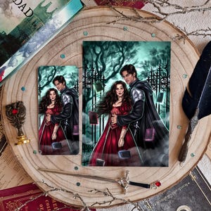 Puede incluir: Dos impresiones artísticas de fantasía que representan a una pareja frente a una puerta, con un fondo de bosque oscuro. La mujer lleva un vestido rojo y el hombre una capa negra. También hay un marcapáginas con la misma imagen. La escena evoca un tema de romance gótico.