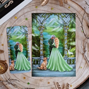 Puede incluir: Una ilustración romántica de una pareja en un entorno de bosque verde. La pareja está de pie bajo un arco de hojas, con un lago y montañas en el fondo. También se incluyen dos perros dorados en la escena.