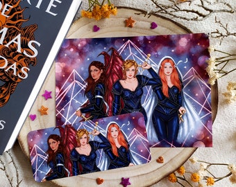 May include: Three women in blue and black armour stand in front of a purple and pink galaxy background. The woman on the left has red wings, the woman in the middle holds a sword, and the woman on the right wears a white veil. The image is a print.