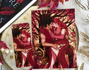 May include: A print depicting a couple embracing, set against a backdrop of a tree with red leaves. The couple are dressed in red and gold clothing, and the woman is wearing a crown. The print is framed and ready to hang.