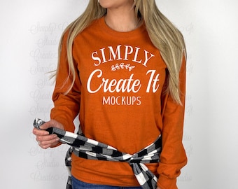 May include: A long-sleeved, burnt orange t-shirt with the text "SIMPLY Create It MOCKUPS" in white lettering.