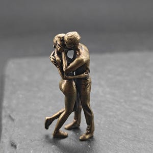 Mini estatua de latón de una pareja apasionada abrazándose y besándose.