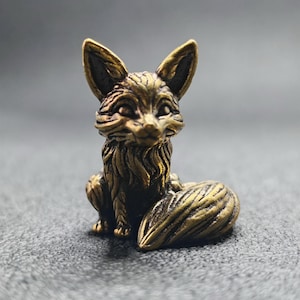 Puede incluir: Figurilla de zorro de bronce detallada, en posición sentada, con intrincados detalles de pelaje y una cola tupida. El zorro tiene orejas grandes y una expresión concentrada. La figurilla es un objeto decorativo, probablemente para exhibición o colección.
