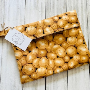 May include: A rectangular fabric pouch with a repeating pattern of brown potatoes. A white tag with the text "MOUNTAIN GIRL creations" is attached with twine. The pouch is open, revealing the interior.