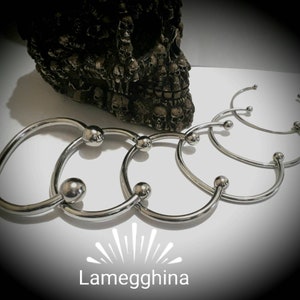 Könnte beinhalten: Fünf silberne Metallringe mit kugelförmigen Enden. Die Ringe sind übereinander gestapelt, wobei der größte Ring unten und der kleinste Ring oben liegt.