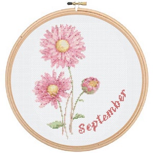 Puede incluir: Arte de bordado en aro con tres flores rosas con centros amarillos y tallos verdes. La palabra "Septiembre" está bordada en rojo debajo de las flores.