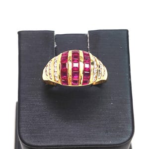 May include: A gold ring with a row of red ruby stones and a row of clear diamonds on each side.