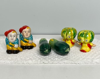 May include: Set of five ceramic salt and pepper shakers. Two are shaped like boys wearing baseball uniforms and holding bats. Two are shaped like green and yellow gourds with faces. One is shaped like a green and yellow courgette.