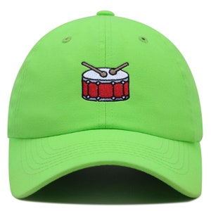 Op de afbeelding: Een felgroene baseballpet met een geborduurd rode trommel en drumsticks.