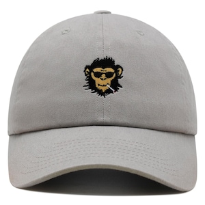 May include: A grey baseball cap with an embroidered image of a monkey wearing sunglasses and smoking a cigarette.
