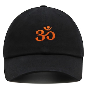 Puede incluir: Una gorra de béisbol negra con un símbolo Om bordado en naranja.