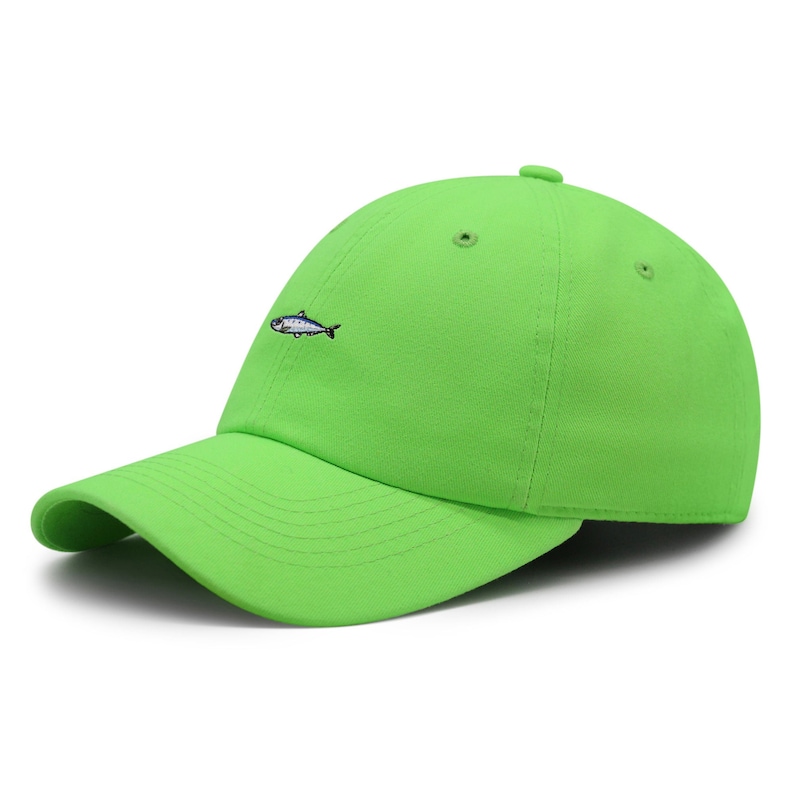 May include: Bright green baseball cap with a curved brim. The cap features a small embroidered fish on the front left side. The cap is made of a soft material and has a button on top.