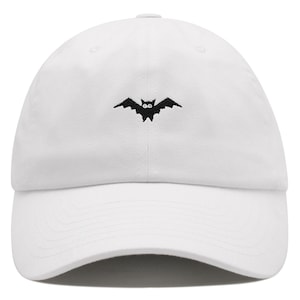 Puede incluir: Gorra de béisbol blanca con un diseño de murciélago bordado en negro.