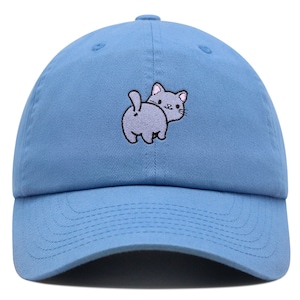 May include: A light blue baseball cap with an embroidered cartoon cat design. The cat is gray and has a pink nose and ears. The cat is looking back over its shoulder.