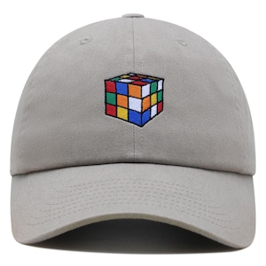May include: A gray baseball cap with an embroidered Rubik's Cube design in various colors.