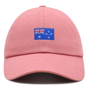 Op de afbeelding: Roze baseballpet met de Australische vlag geborduurd op de voorkant. De vlag is een blauwe rechthoek met de Union Jack en het sterrenbeeld Zuiderkruis.