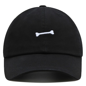 May include: A black baseball cap with a white bone embroidered on the front.