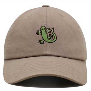 Può includere: Un cappello da baseball color kaki con un design di lucertola verde ricamato.