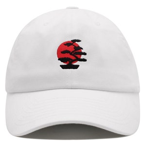 May include: White baseball cap with an embroidered design of a red sun and a black bonsai tree.